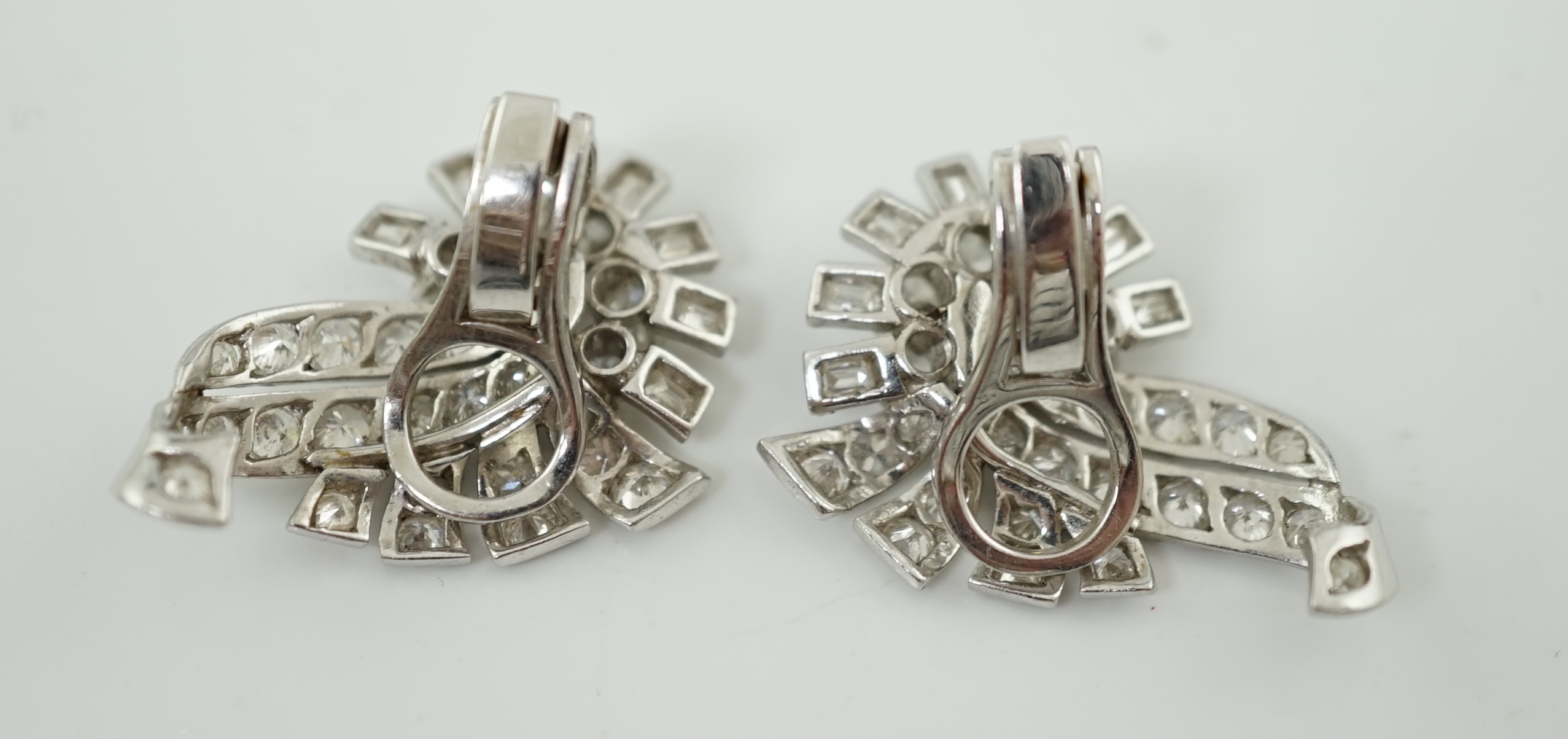 A pair of platinum and diamond cluster scroll ear clips